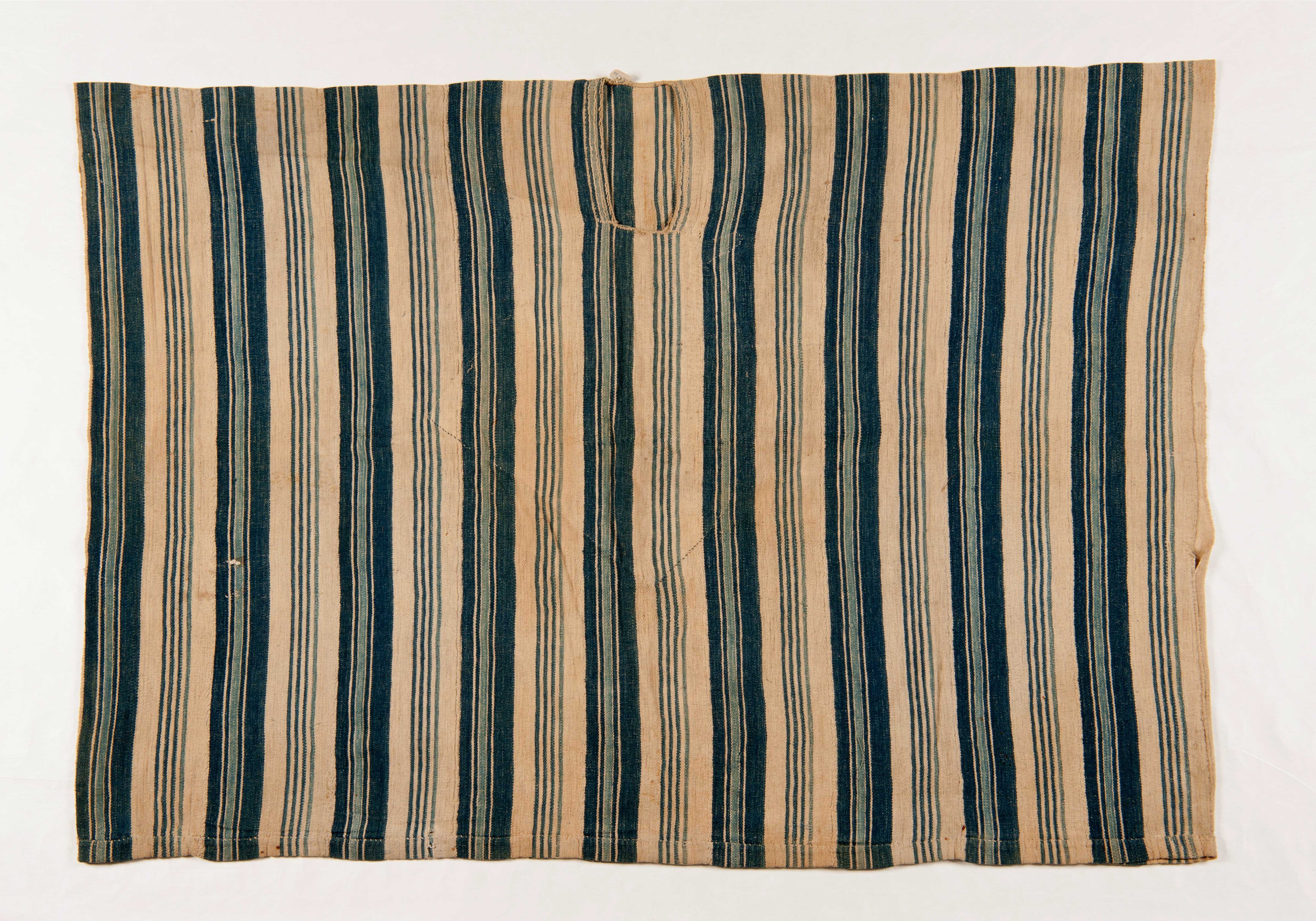 Boubou van wit gestreept katoen uit Sierra Leone. De strepen lopen verticaal en variëren van donkerblauw tot hemelsblauw. Het werd door het museum aangekocht tijdens de Wereldtentoonstelling in Parijs in 1889. (RV-747-10)