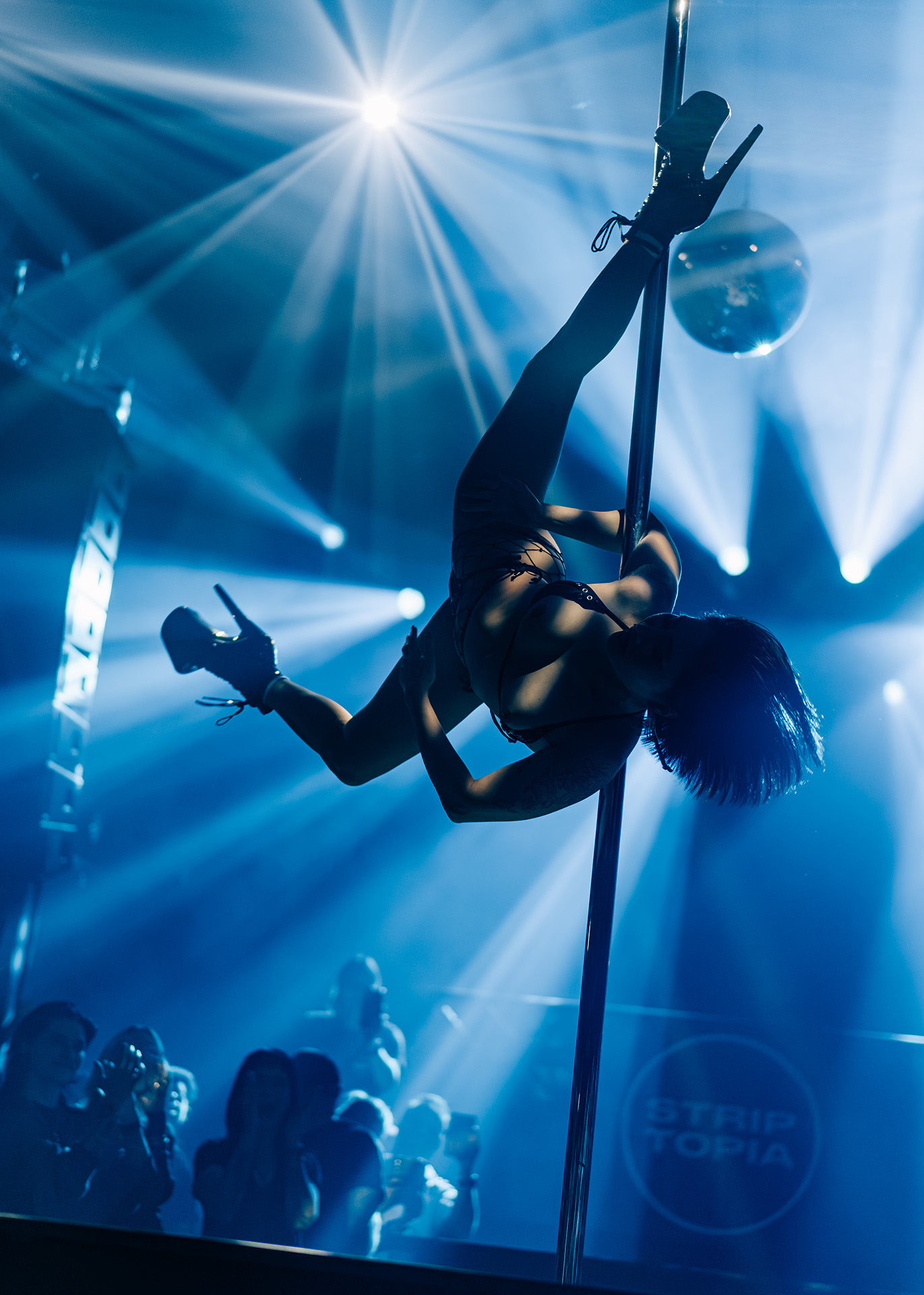 Stripper die ondersteboven aan een paal hangt 