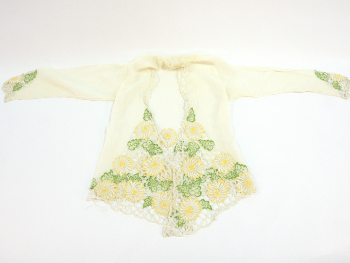 Witte kebaya waarbij de voorkant in een punt uitloopt. Met geel en groen borduurwerk (chrysanten en margrieten). Bogor regentschap, 1930-1950. (7082-S-2335-2)